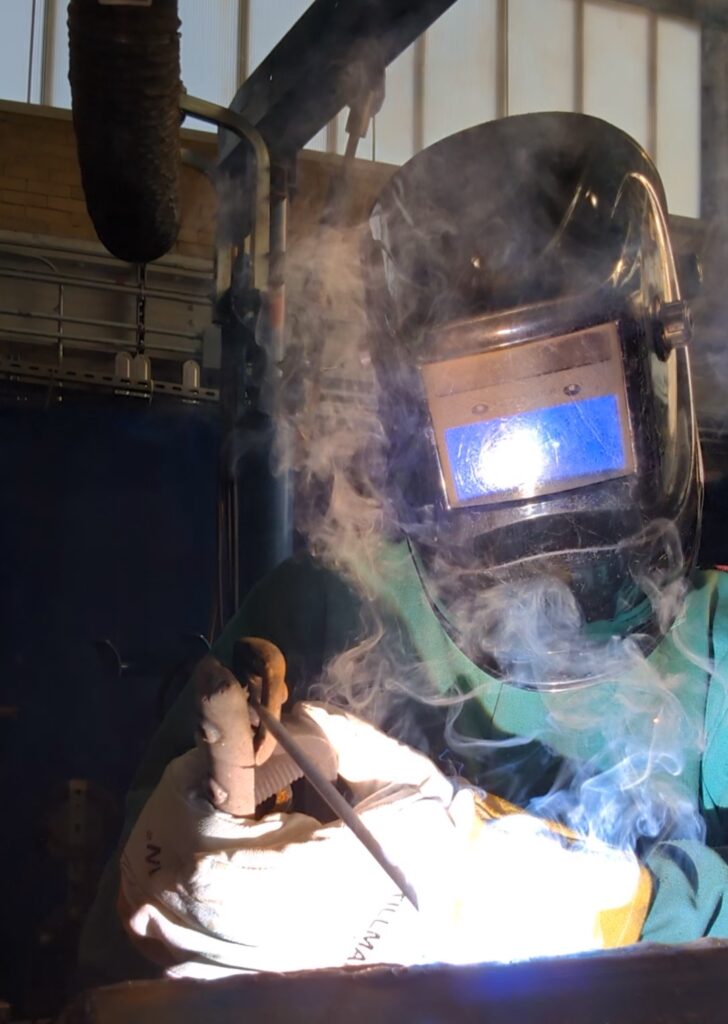 a welder with sparks flying in front of their mask